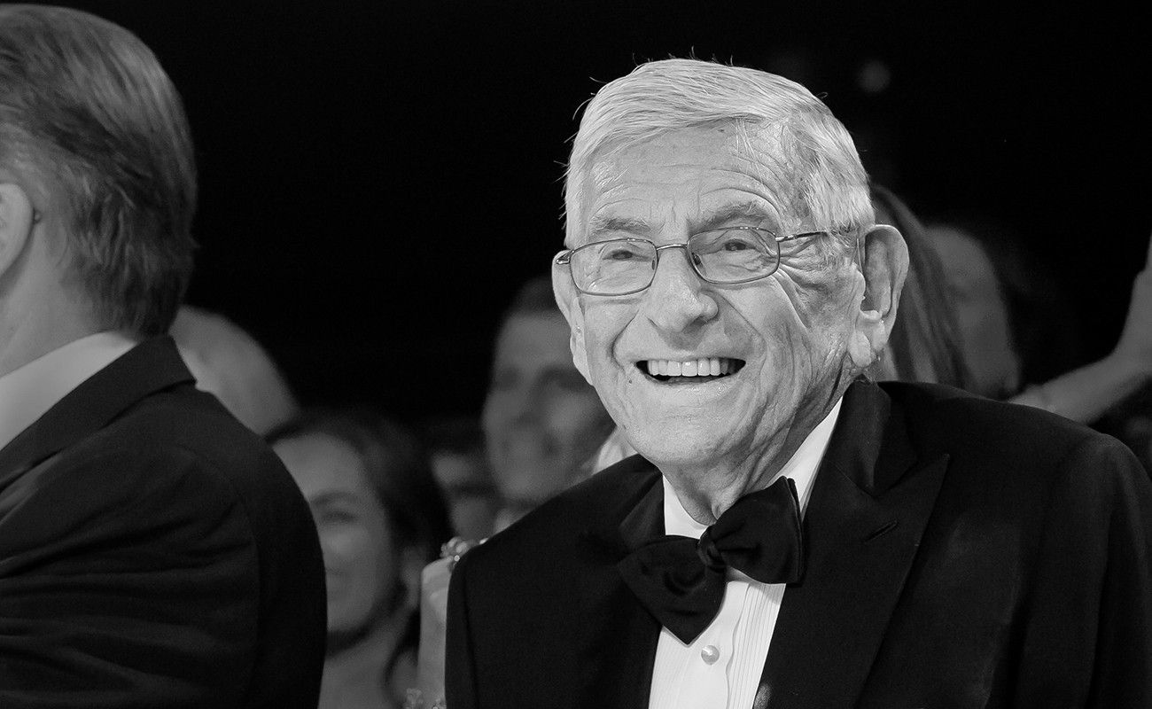 Black and White photo Eli Broad smiling wearing a black tuxedo with bow tie