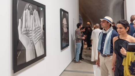 Photo of visitors looking at Shirin Neshat's work.