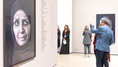 Photo of visitors looking at Shirin Neshat's work.